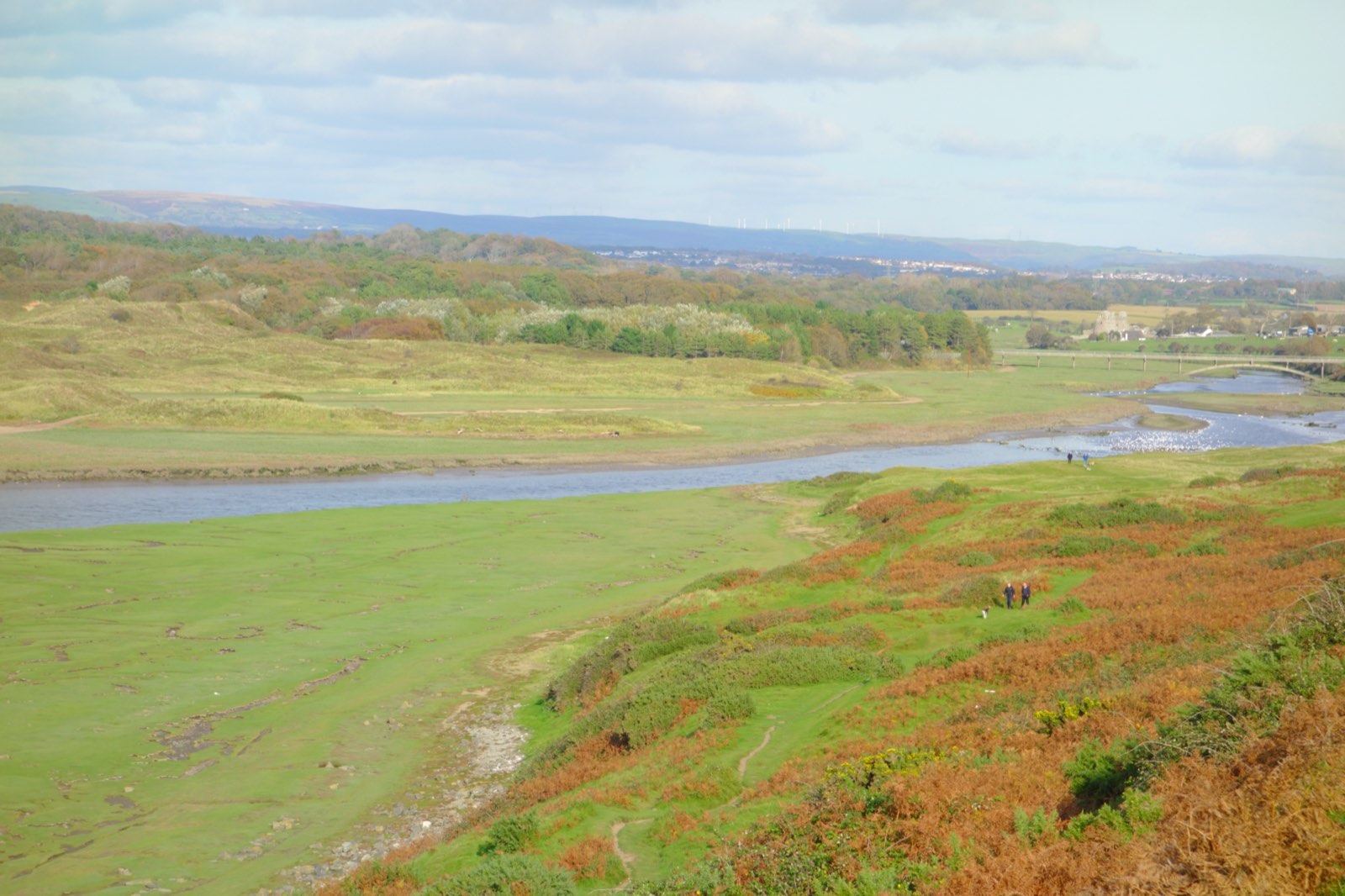 The ruins of Ogmore Castle seen across the river meadows